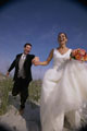recem casados correndo de mãos dadas com um bouquet de noiva e flores