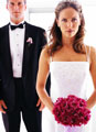 Casal de noivos a posar para foto com bouquet de rosas vermelhas e vestido de casamento