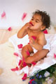 Bebé a brincar com pétalas de rosa