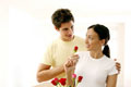 Olhar cúmplice entre namorados enquanto partilham rosas