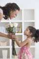 Menina a oferecer à sua mãe um ramo de flores